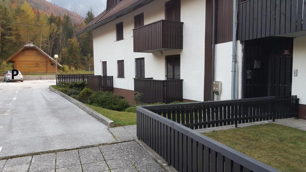 un edificio blanco con una valla negra junto a una entrada en Apartment HM, en Gozd Martuljek