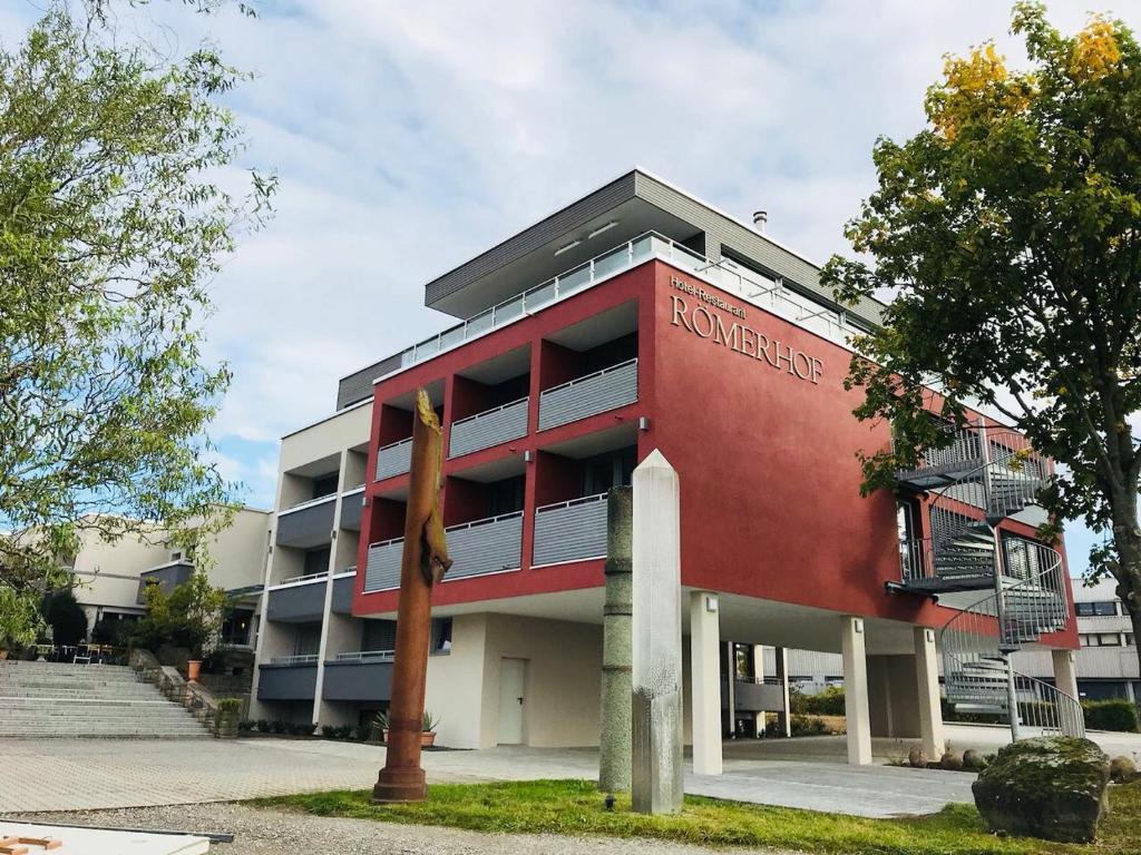 un bâtiment rouge avec un panneau sur son côté dans l'établissement Hotel-Restaurant Römerhof, à Herrenberg