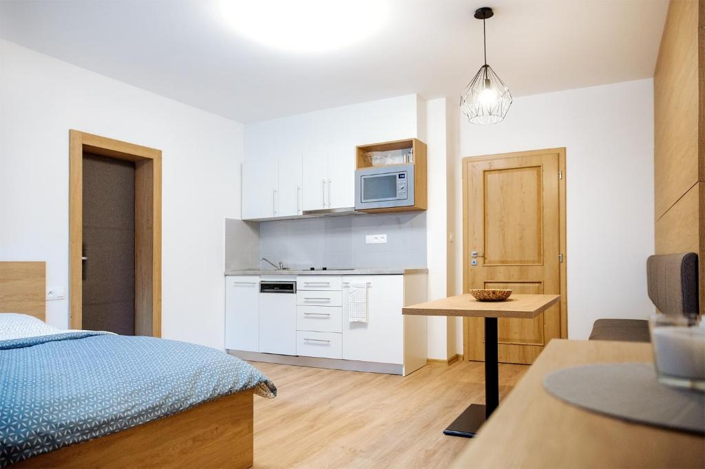 - une petite cuisine avec un lit et un four micro-ondes dans l'établissement Apartmány Na Čtvrtích, à Dolní Bečva