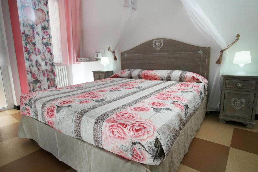 una camera da letto con un letto con copriletto floreale di Milano Affittacamere a Milano