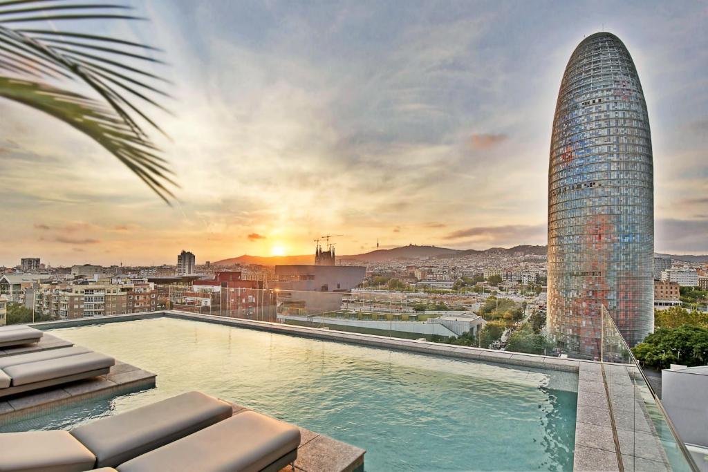 ein Pool auf dem Dach eines Gebäudes mit einem Wolkenkratzer in der Unterkunft Hotel SB Glow 4 Sup in Barcelona