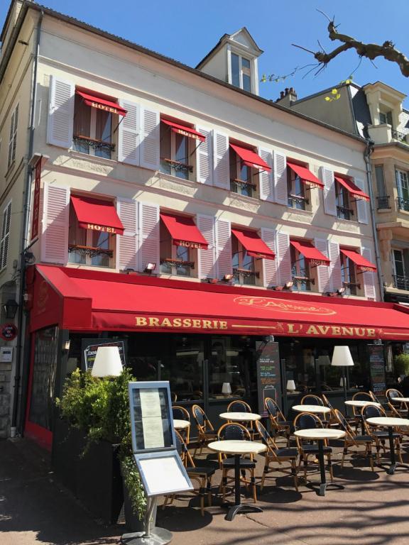 un groupe de tables et de chaises devant un bâtiment dans l'établissement Hotel l'Avenue, à Chantilly