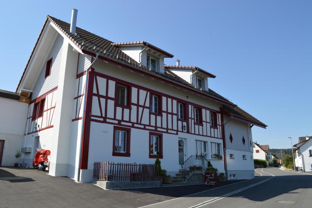 a white house with red and white trim at BnB zum Schlüssel in Unterehrendingen