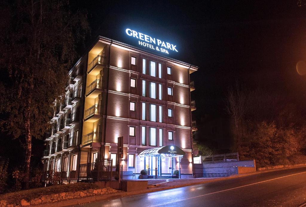 a building with a sign on top of it at night at Green Park Hotel & SPA in Truskavets