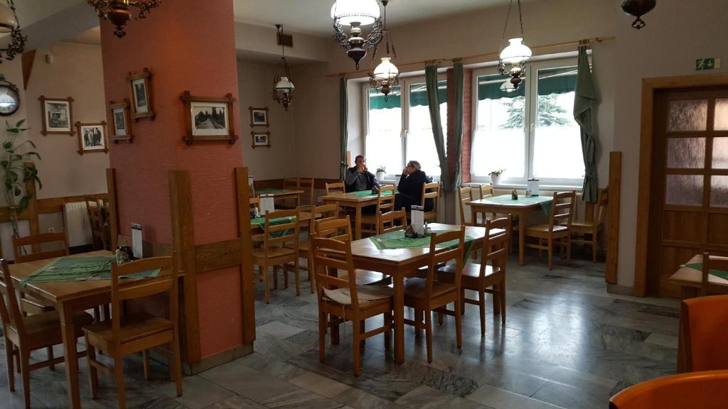 zwei Personen, die in einem Restaurant an Tischen sitzen in der Unterkunft Hotel Lidový dům in Nový Hrozenkov