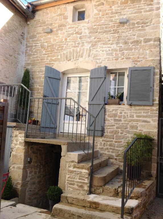 uma casa de pedra com escadas que levam a uma porta em Gite le murger em Meursault