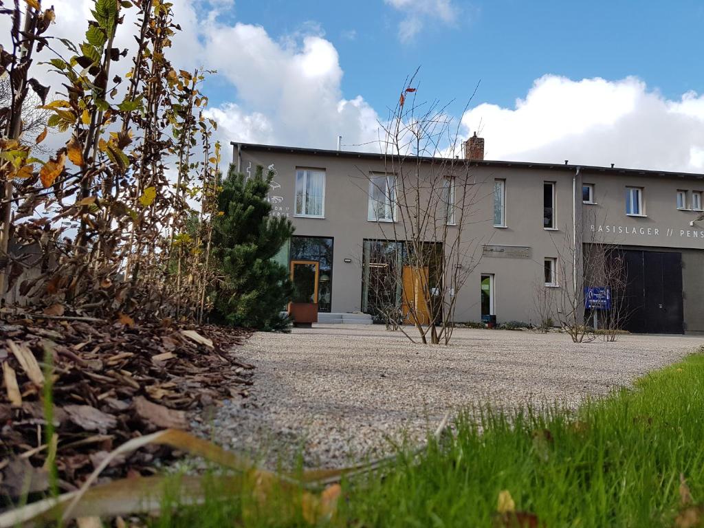 - un grand bâtiment blanc avec une allée devant dans l'établissement Velo Inn Basislager Bad Berka, à Bad Berka