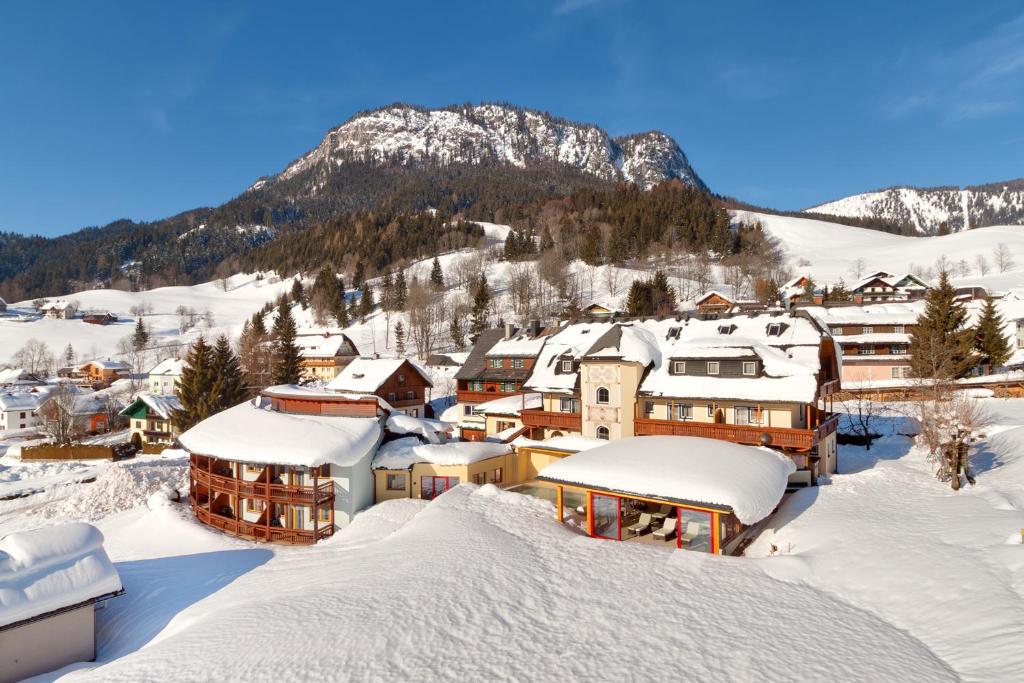 una ciudad cubierta de nieve con una montaña en el fondo en Der Hechl, en Tauplitz