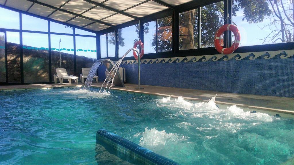 a pool with a water slide in a building at Hotel San Millán in Santander