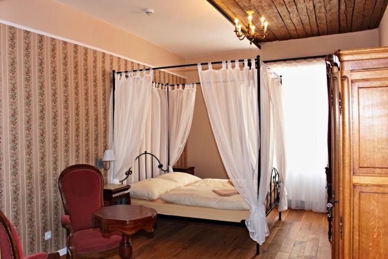 a bedroom with a bed and a table and a window at Penzion Kasper Cyklopenzion in Jindrichuv Hradec