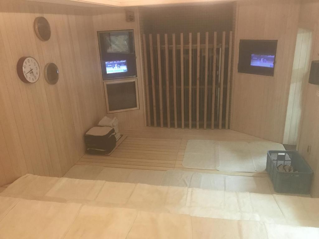 um quarto vazio com um relógio na parede em Capsule&Spa Grand Sauna Hiroshima (Male Only) em Hiroshima