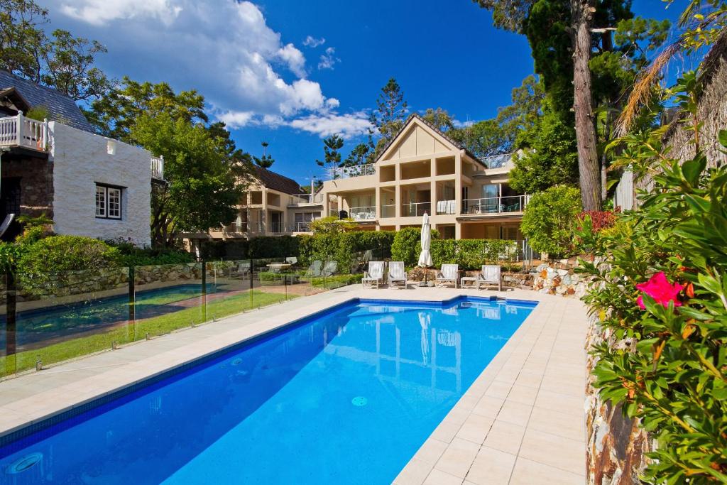 a swimming pool in front of a house at Tranquil Little Cove Unit, Pool Escape in Noosa Heads