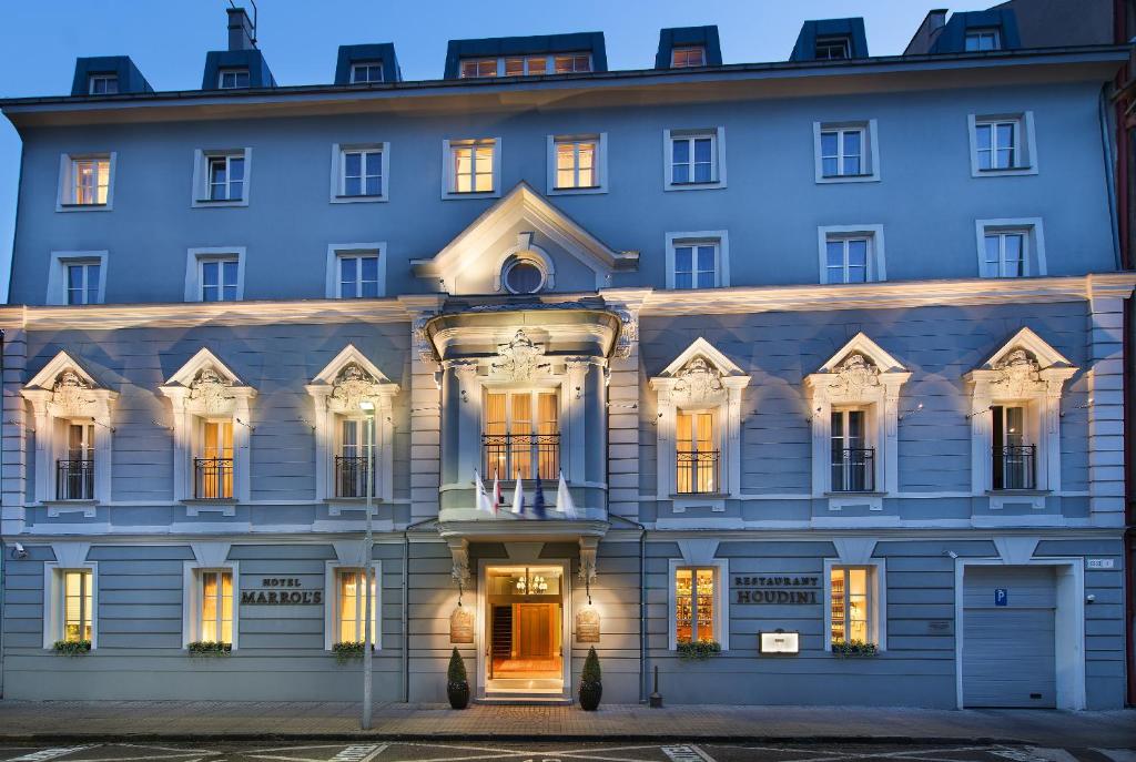 ein großes blaues Gebäude mit eingeschalteten Lichtern in der Unterkunft Marrol's Boutique Hotel in Bratislava