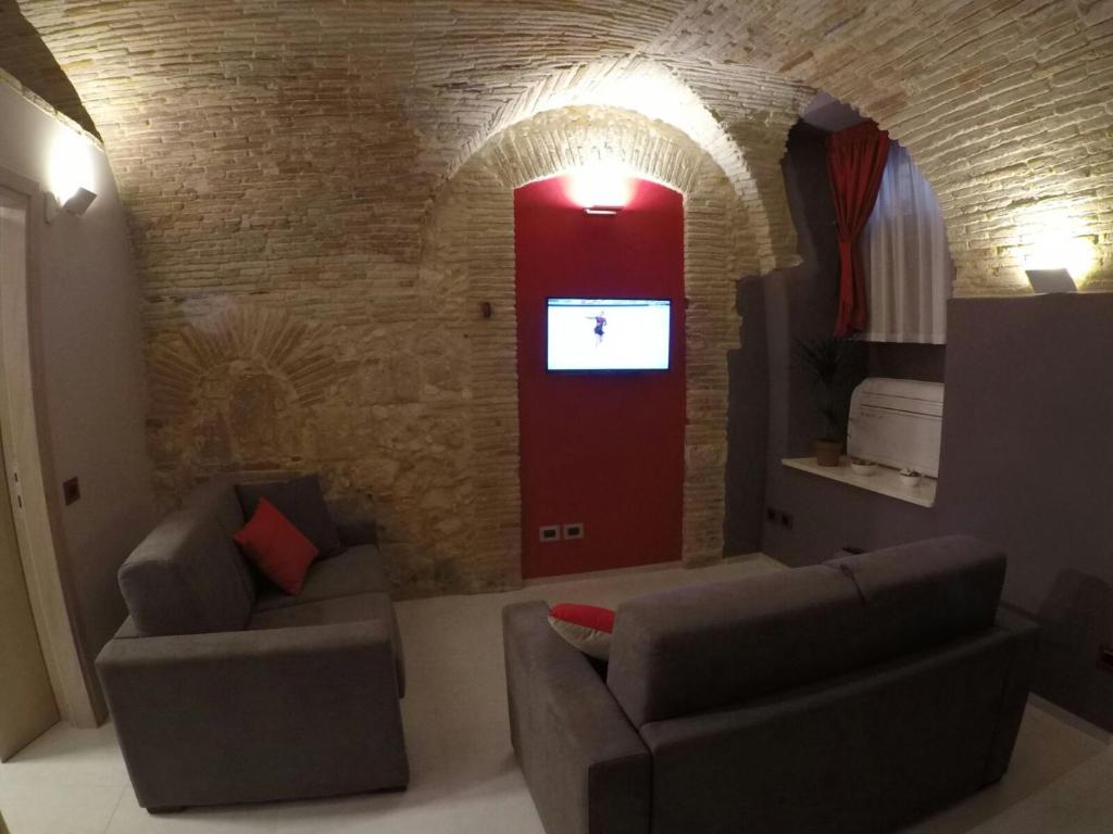 uma sala de estar com dois sofás e uma porta vermelha em Al Castello em Cagliari