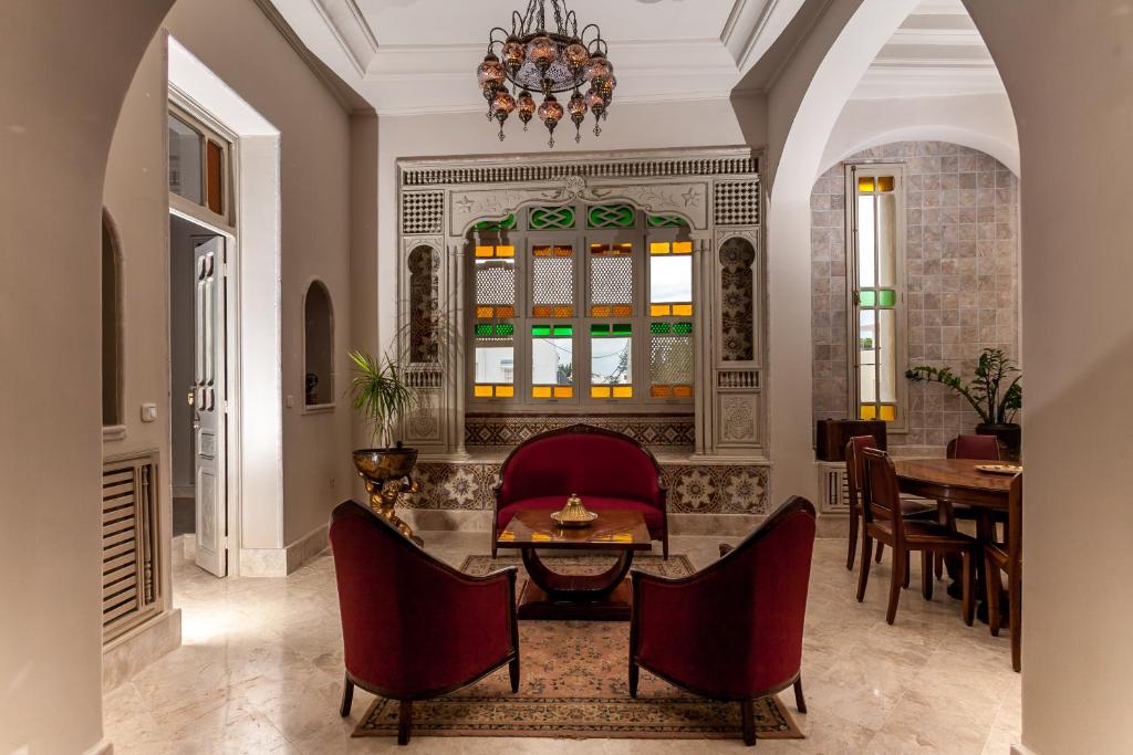 a living room with a table and chairs at Maison d'Hôtes Dar Ennassim in La Marsa