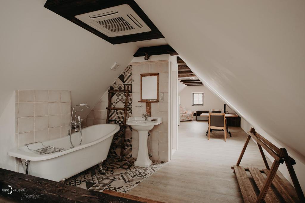 a bathroom with a bath tub and a sink at Penzion Víno Hruška Pardubice in Pardubice