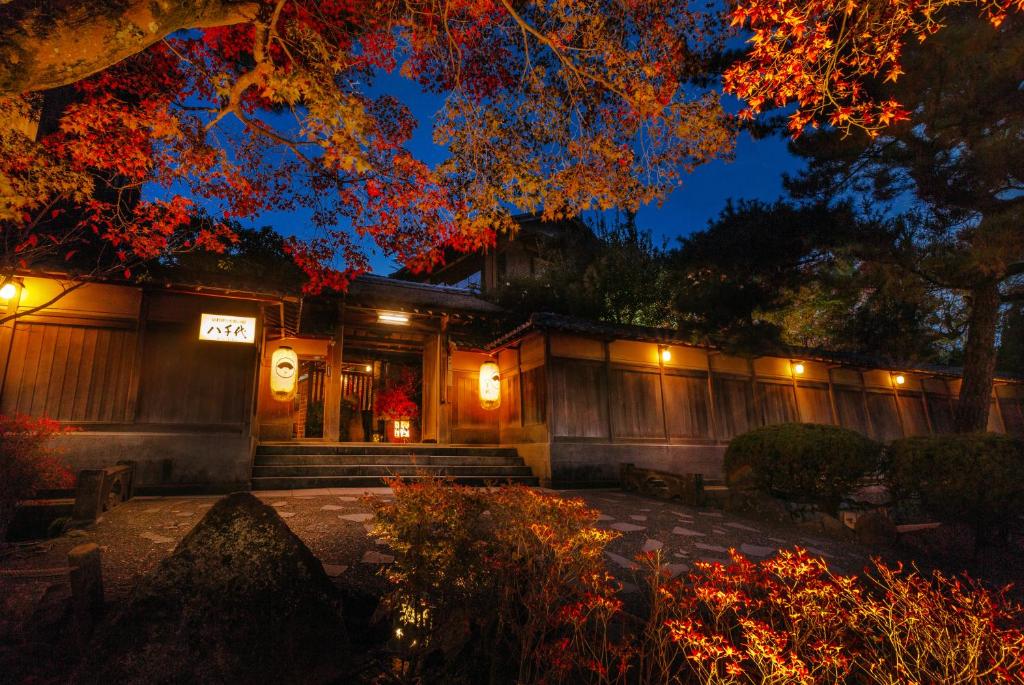 un bâtiment avec des lumières devant lui la nuit dans l'établissement Kyoto Nanzenji Ryokan Yachiyo Established in 1915, à Kyoto