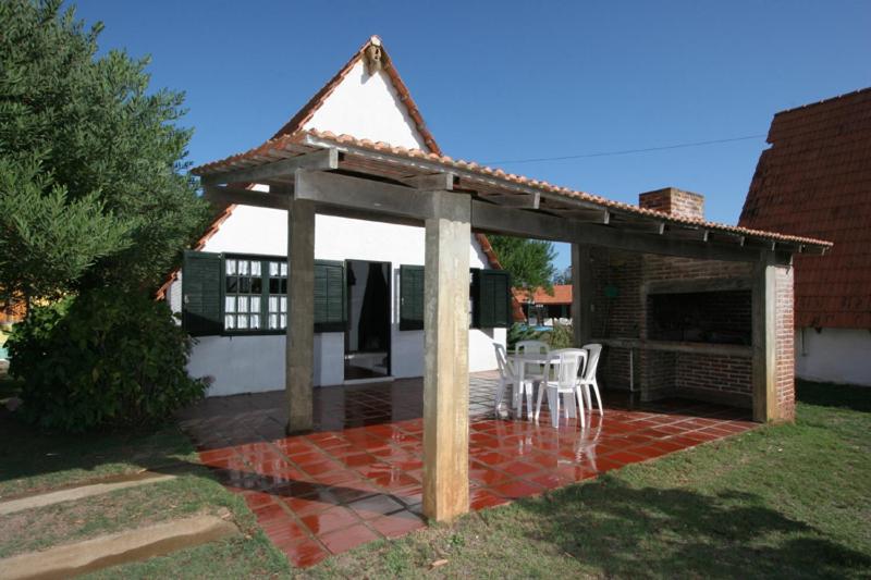 een paviljoen met een tafel en stoelen op een patio bij Complejo Turístico Anaconda Cabañas in La Paloma