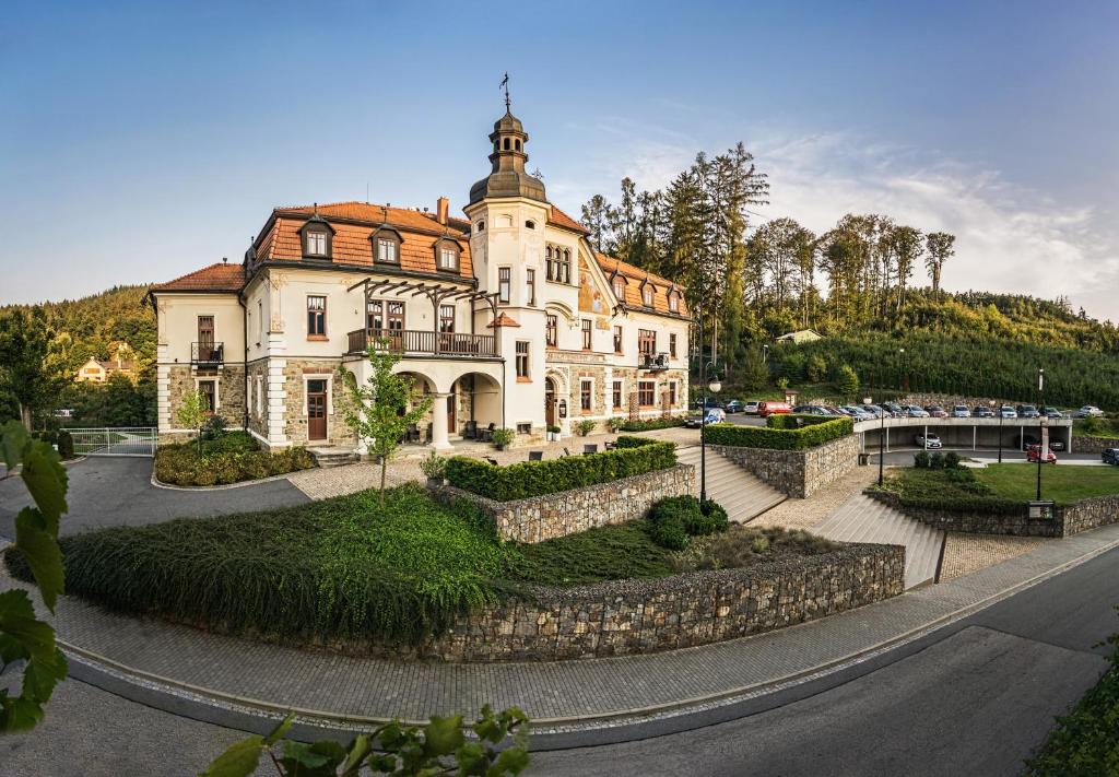 ein großes Gebäude mit einem Turm darüber in der Unterkunft Wellness & spa hotel Augustiniánský dům in Luhačovice