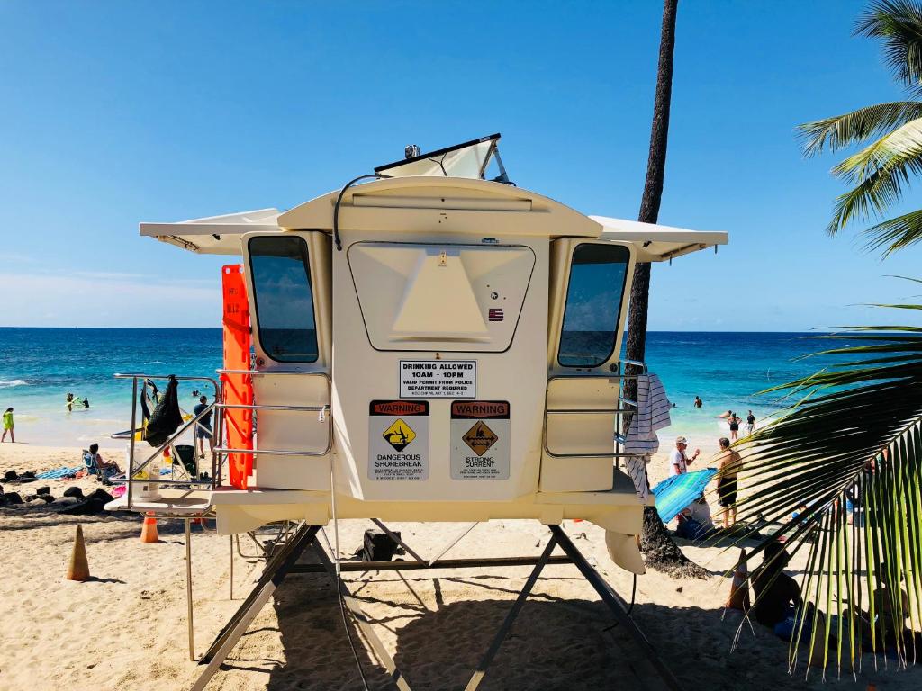 ein Wohnmobil, der mit Leuten am Strand parkt in der Unterkunft Kona Magic Honu Room in Kailua-Kona