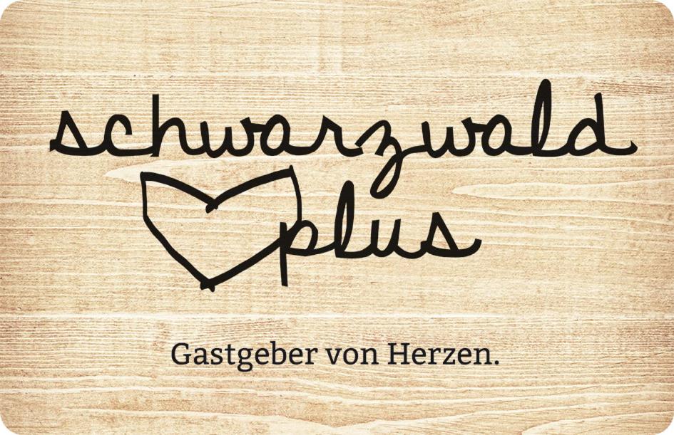 a handwritten sign with a heart on a wooden table at Ferienwohnung Kaufmann in Baiersbronn