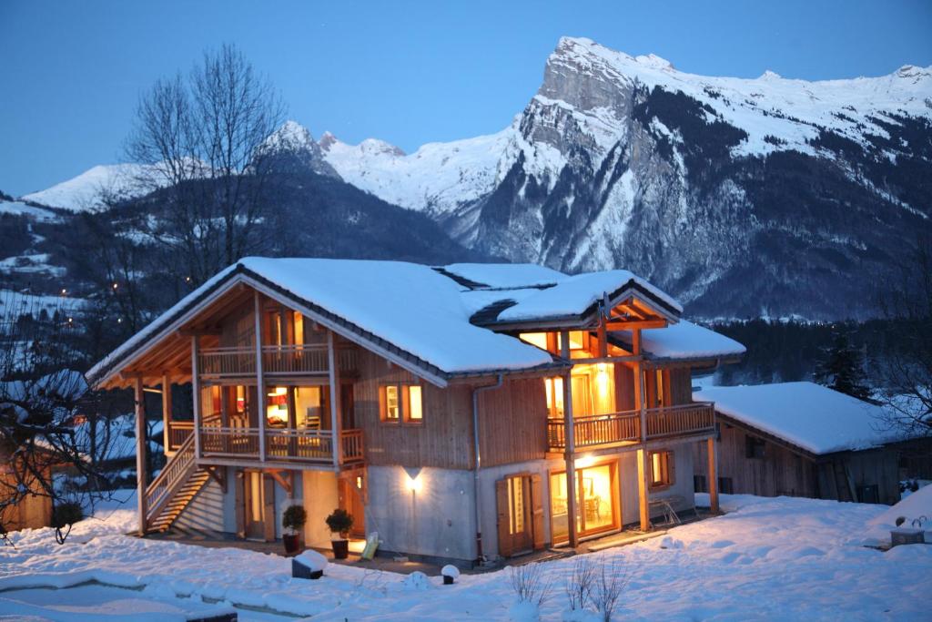 een blokhut in de sneeuw met een berg bij Chalet Brio in Samoëns