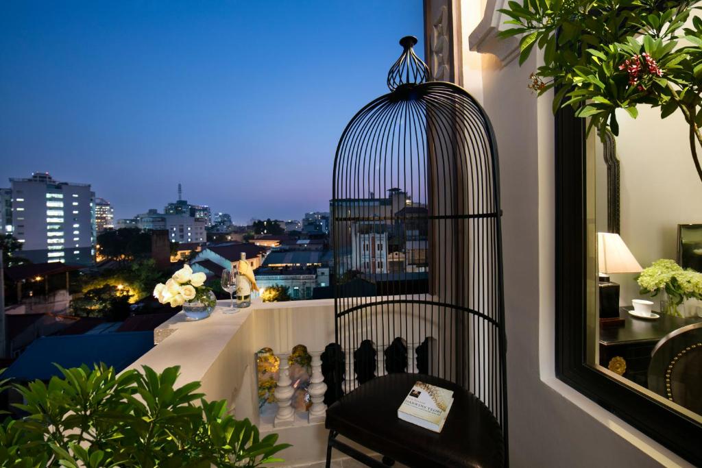 une cage pour oiseaux assise au-dessus d'un balcon dans l'établissement Hanoi Center Silk Premium Hotel & Spa & Travel, à Hanoï