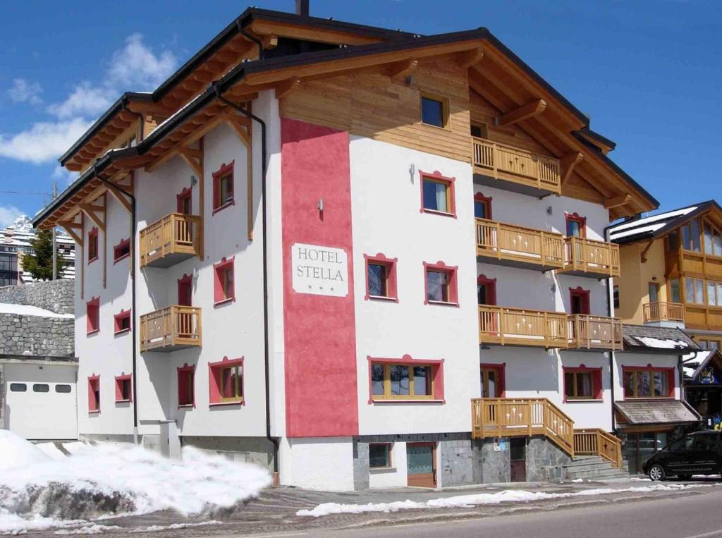 un immeuble d'appartements avec un rouge et un blanc dans l'établissement Hotel Stella, à Passo del Tonale