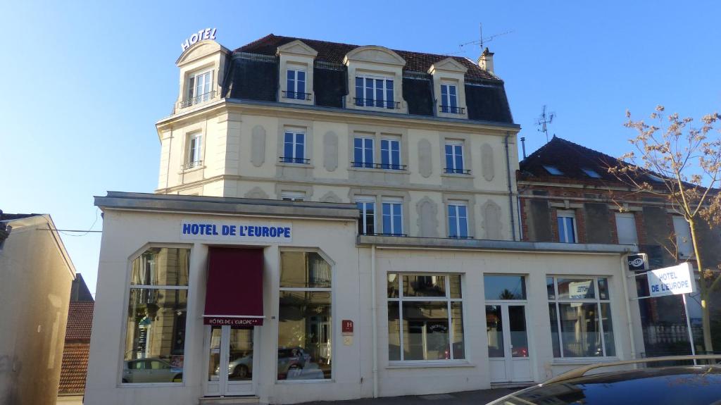 un edificio bianco con una torre dell'orologio sopra di Hotel De L'Europe a Toul