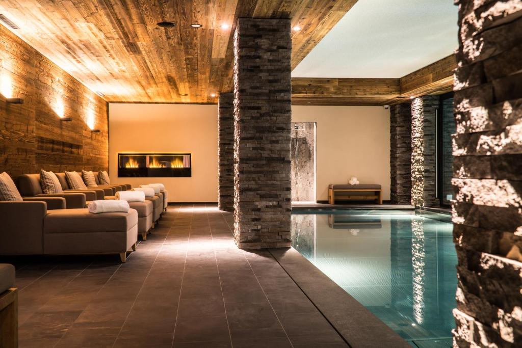 ein Wohnzimmer mit einem Pool in der Mitte eines Hauses in der Unterkunft The Capra Saas-Fee in Saas-Fee