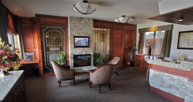 een lobby met stoelen en een open haard in een kamer bij Motel Du Chevalier in Gatineau