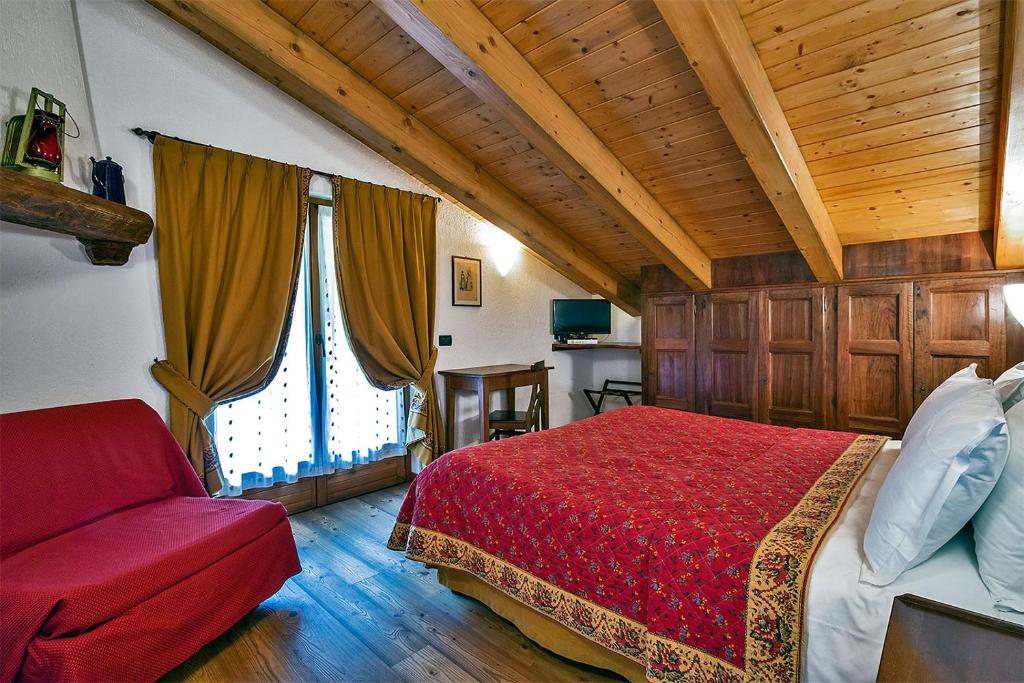 ein Schlafzimmer mit einem roten Bett und einem roten Sofa in der Unterkunft Hotel Lo Campagnar in Courmayeur