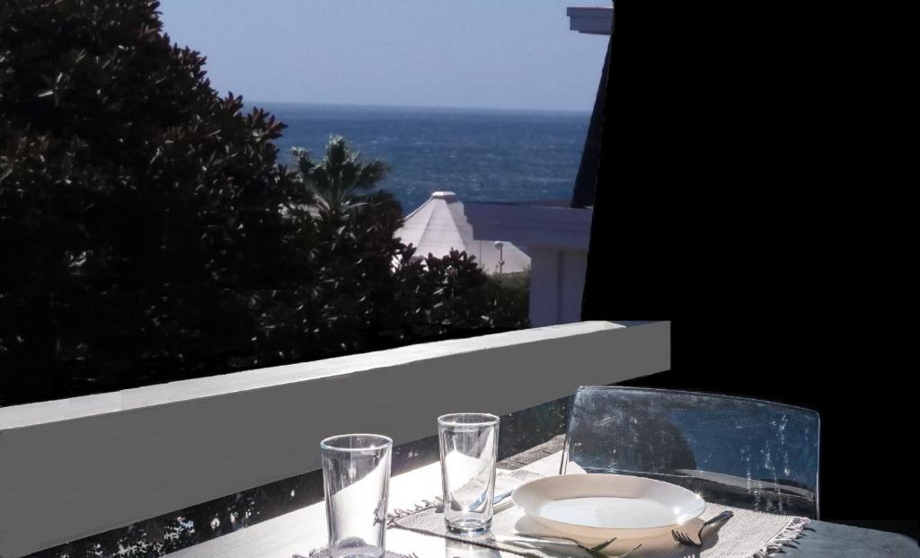 stół z talerzem i kieliszkami na balkonie w obiekcie Cascais-Estoril BEACHFRONT Apartments w mieście Estoril