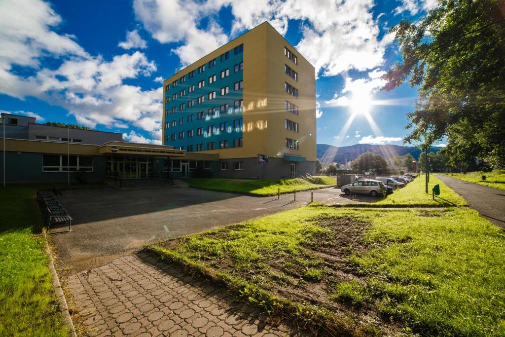 un edificio en una calle con el sol detrás en Hotel M, en Jeseník