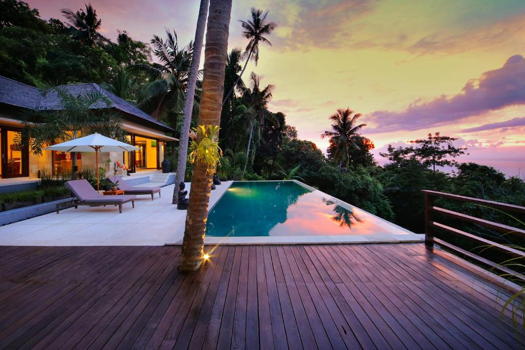 a villa with a swimming pool on a wooden deck at Villa Marley in Senggigi 