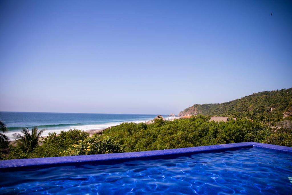 een zwembad met uitzicht op het strand bij Hotel El Copal in Mazunte