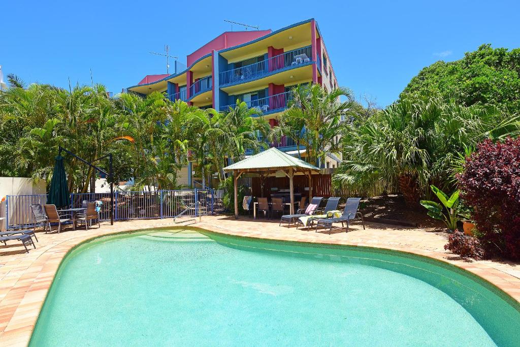 a swimming pool in front of a hotel at Lindomare Apartments in Caloundra