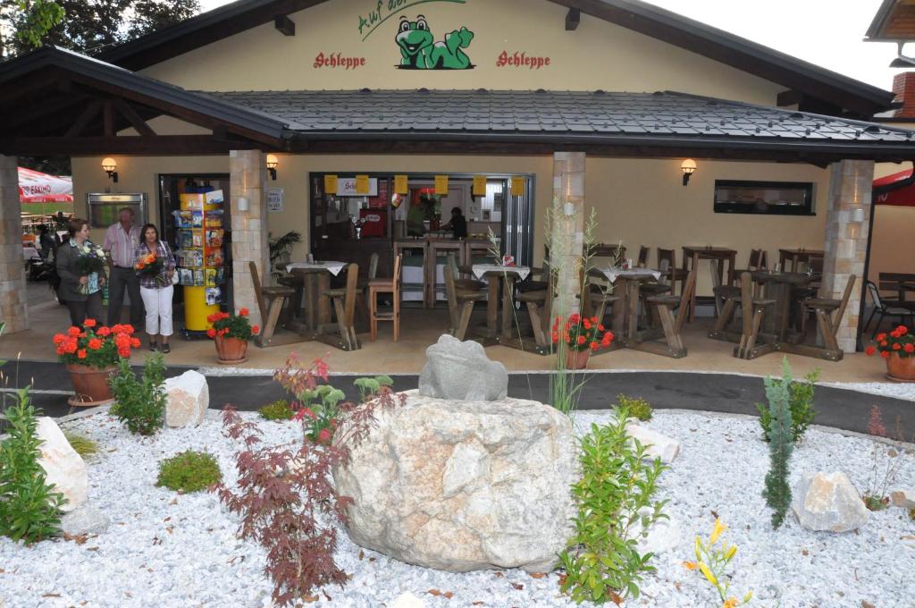 un restaurant avec un grand rocher en face dans l'établissement Gasthof Plasch, à Ferlach