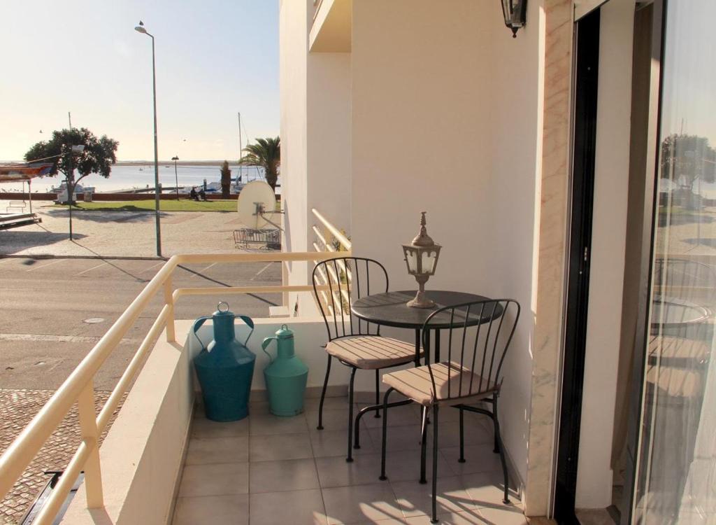 d'une table et de chaises sur un balcon avec vue sur l'océan. dans l'établissement Casa Esti, à Olhão