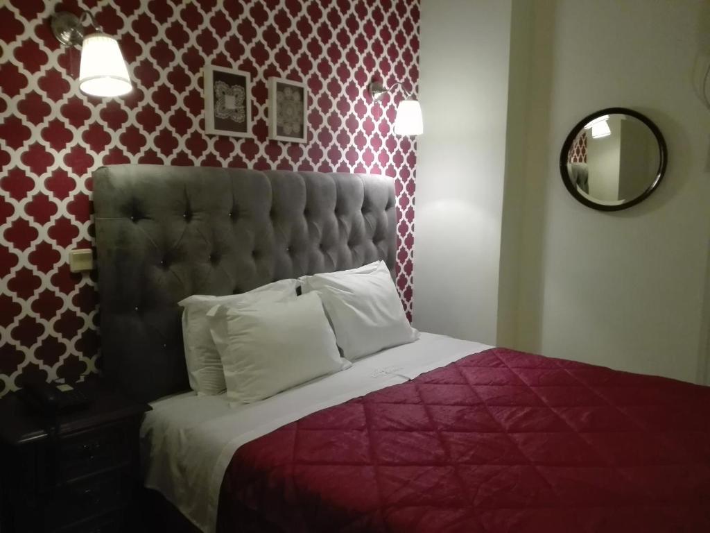 - une chambre avec un lit et une couette rouge dans l'établissement Hotel Kamanga, à Tomar