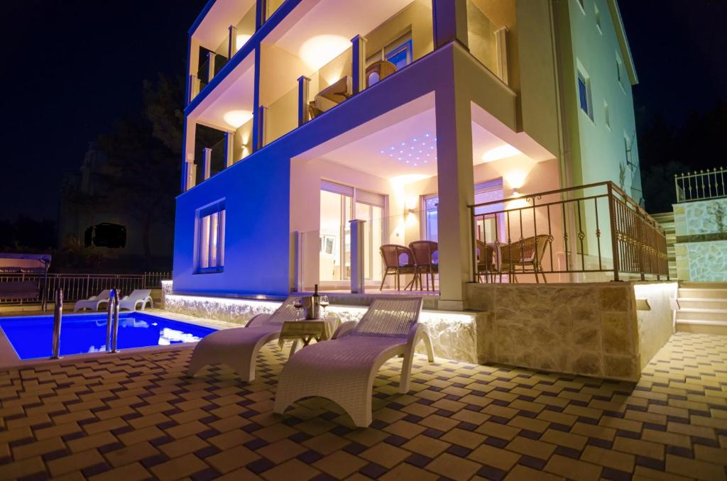 トロギールにあるLuxury Villa Star Lights Trogir - heated pool, hot tub, gym, billiardの夜間のスイミングプール付きのヴィラ