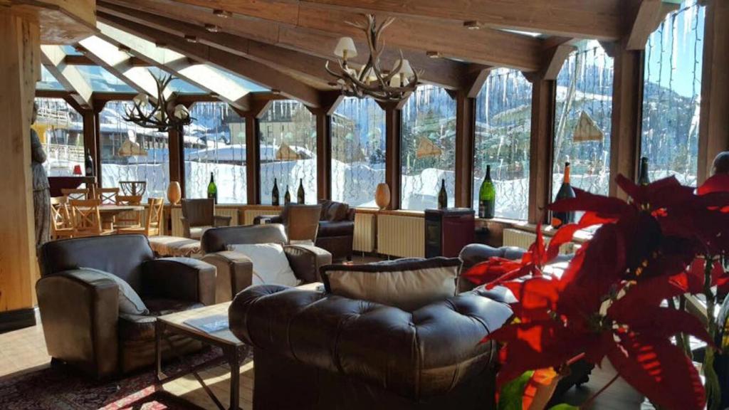 a living room with couches and tables and windows at Grand Hotel Sestriere in Sestriere