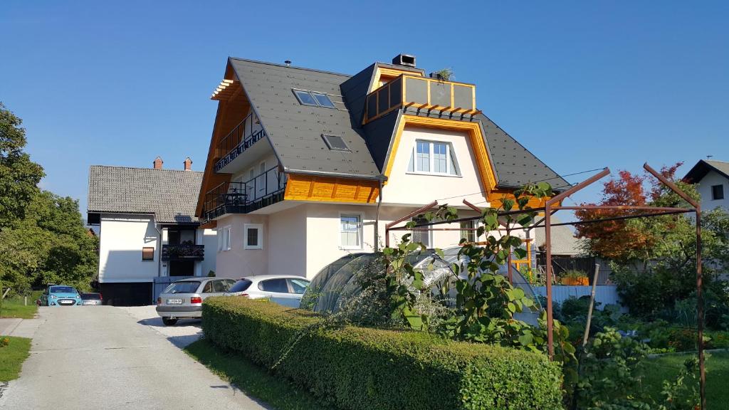 uma grande casa branca com um telhado preto em Vila Rajska ptica em Bled