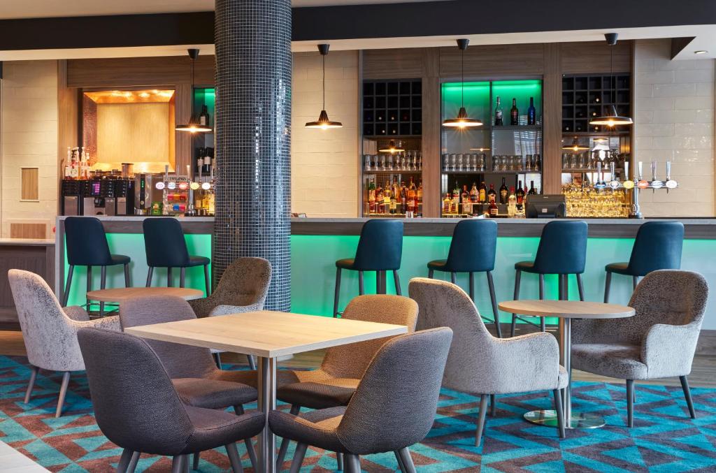 a restaurant with tables and chairs and a bar at Leonardo Hotel Southampton in Southampton