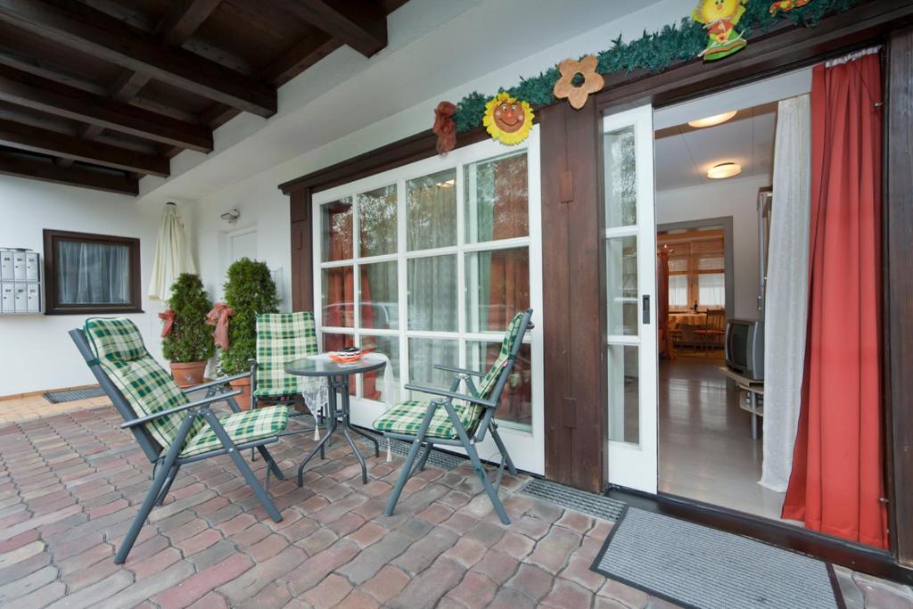 eine Terrasse mit Stühlen und einem Tisch vor einer Tür in der Unterkunft Ferienwohnung Pali in Sankt Johann in Tirol