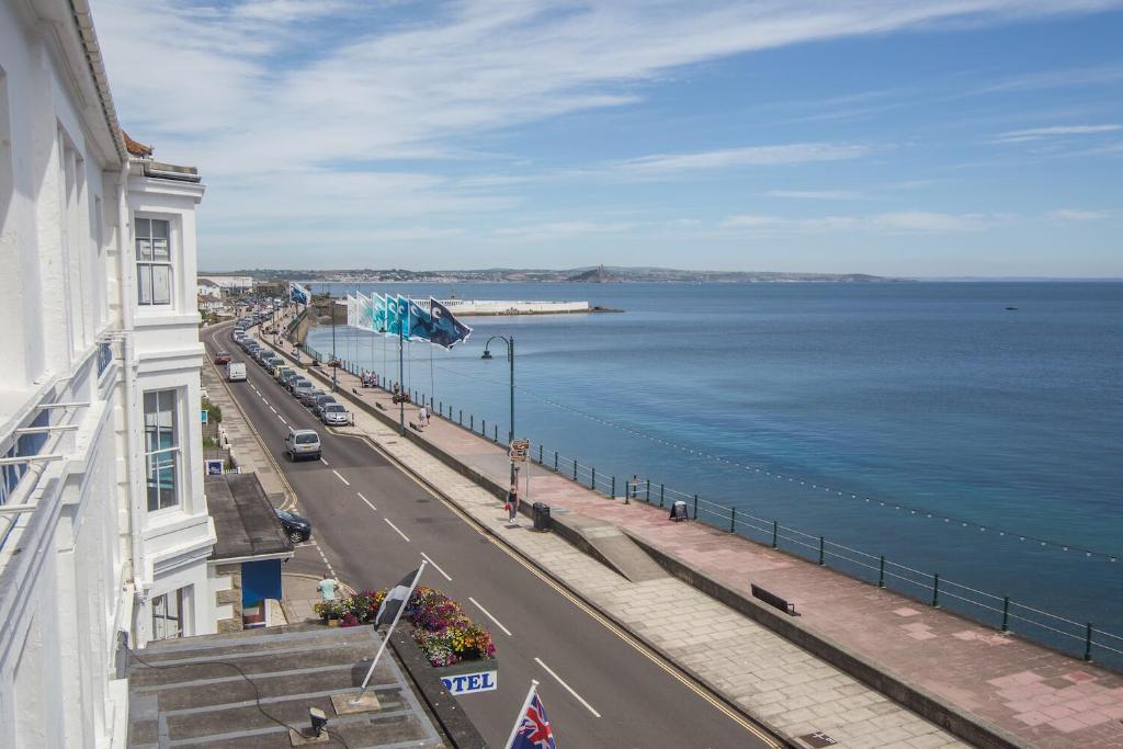 uma vista para uma rua e para o oceano a partir de um edifício em The Queens Hotel em Penzance