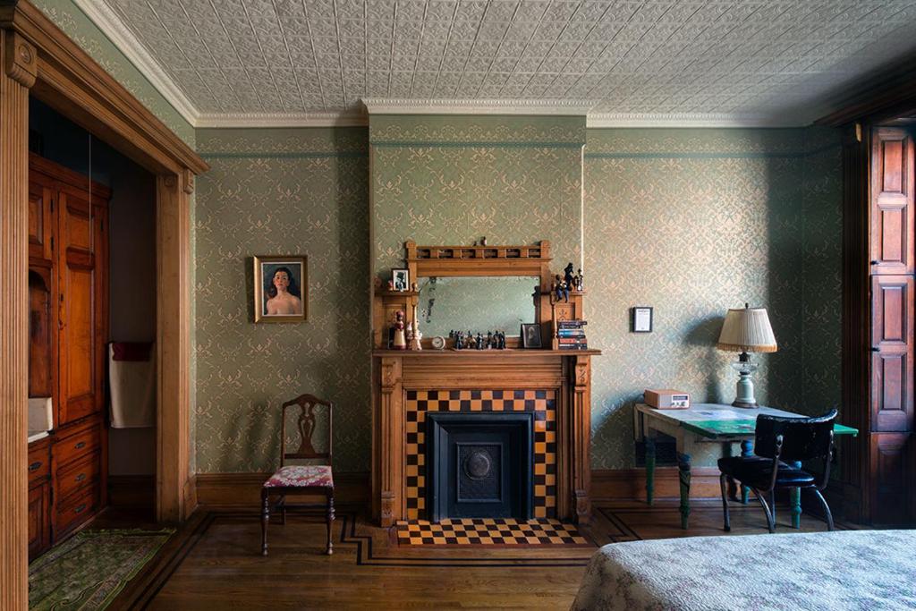 een slaapkamer met een open haard, een tafel en een bed bij The Harlem Flophouse in New York