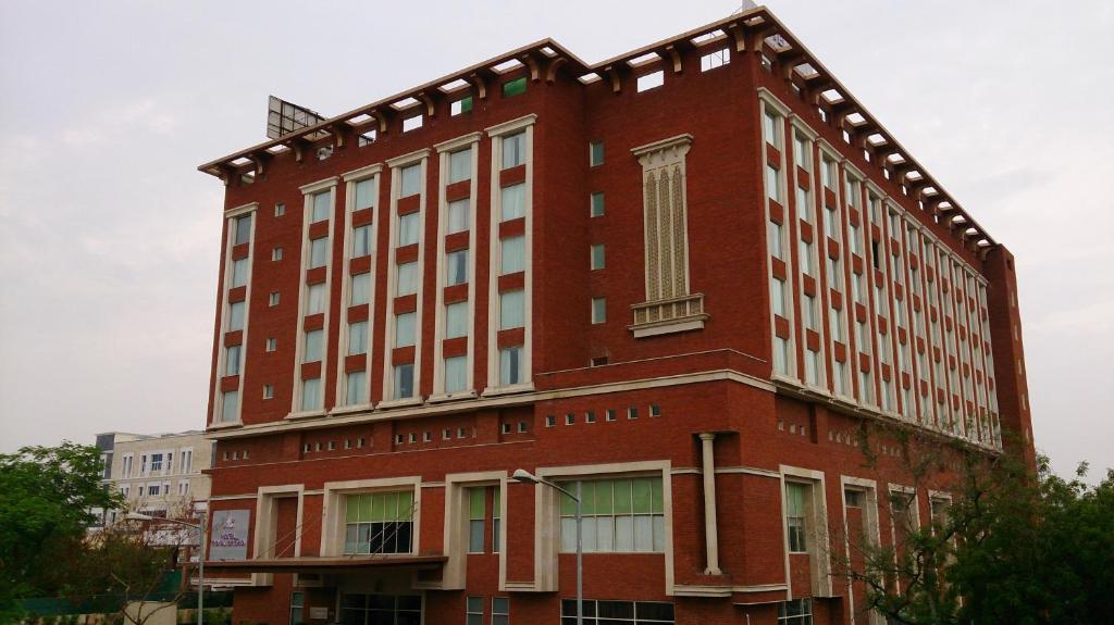 um grande edifício de tijolos vermelhos com uma janela em Hotel Royal Orchid Jaipur, Tonk Road em Jaipur