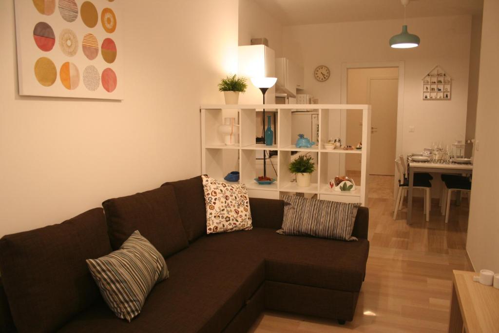 a living room with a brown couch and a dining room at Casa Palladio in Vicenza