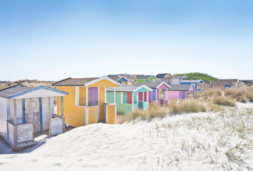 a row of colorful beach houses on the beach at Skanörs Gästgifvaregård in Skanör med Falsterbo